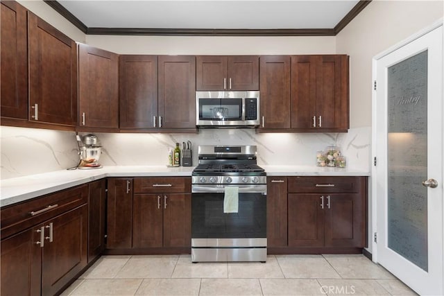 kitchen featuring tasteful backsplash, light tile patterned floors, dark brown cabinetry, stainless steel appliances, and crown molding