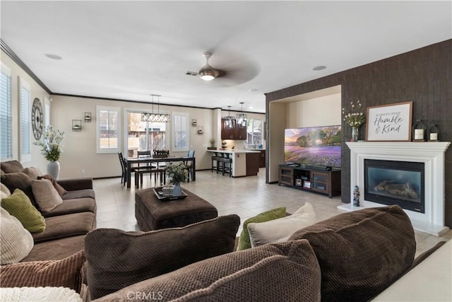 tiled living room with ornamental molding and ceiling fan