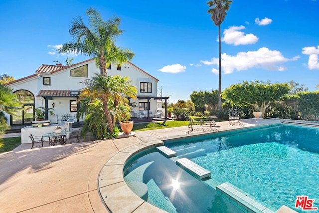 view of swimming pool featuring an in ground hot tub and a patio area