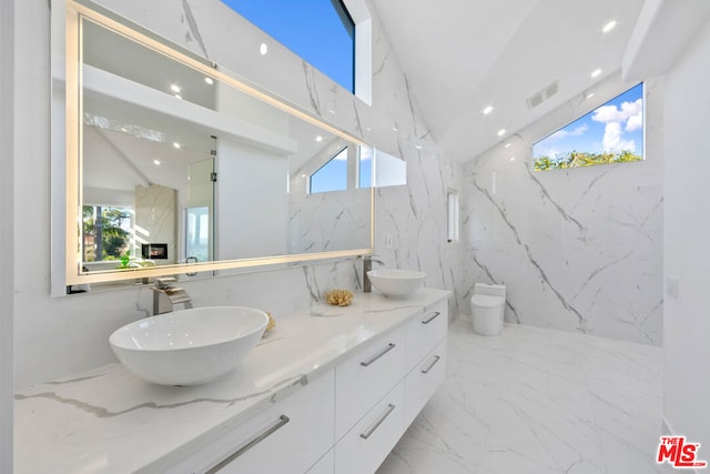 bathroom featuring vanity, vaulted ceiling, and toilet