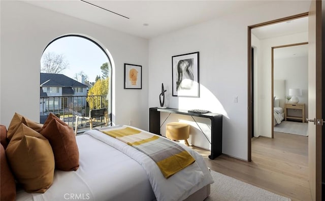 bedroom featuring access to exterior and light wood-type flooring