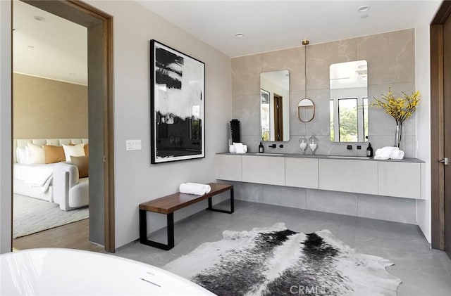 bathroom featuring concrete flooring, vanity, and a washtub