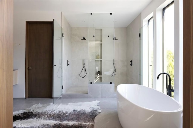 bathroom featuring shower with separate bathtub and concrete floors