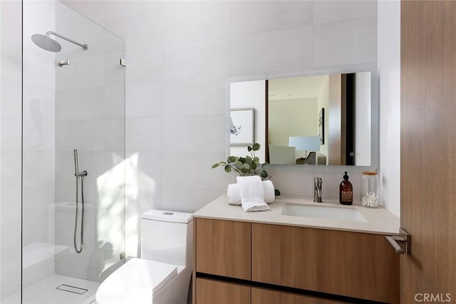 bathroom featuring vanity, tiled shower, tile walls, and toilet