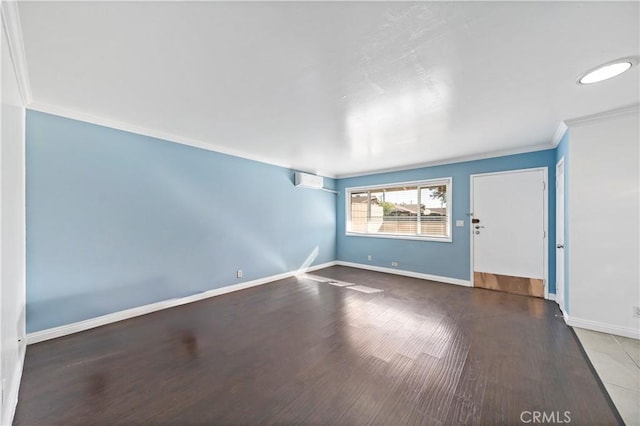 spare room featuring ornamental molding, a wall mounted AC, and wood-type flooring