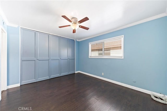 unfurnished bedroom with crown molding, ceiling fan, dark hardwood / wood-style flooring, and a closet