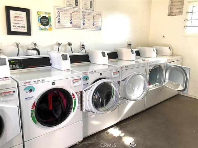 clothes washing area with washing machine and dryer