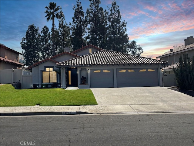 view of front of house with a garage and a yard