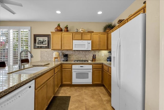 kitchen featuring sink, white appliances, ceiling fan, backsplash, and kitchen peninsula