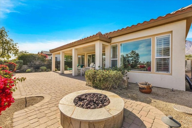 back of house featuring an outdoor fire pit and a patio area