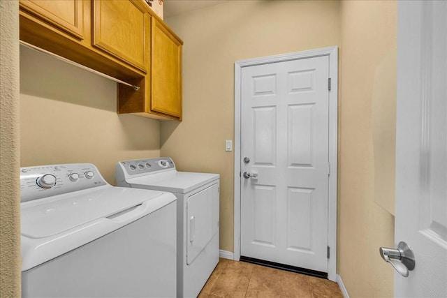 laundry room with cabinets, light tile patterned floors, and washing machine and clothes dryer