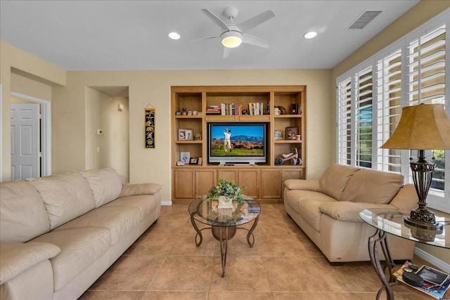 living room featuring built in features, ceiling fan, and light tile patterned flooring