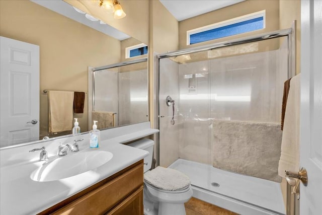 bathroom with vanity, tile patterned floors, a shower with door, and toilet