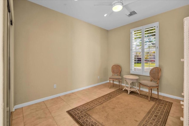 living area featuring light tile patterned floors and ceiling fan