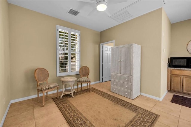 living area with light tile patterned flooring and ceiling fan