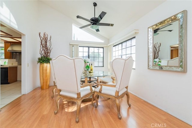 dining area featuring ceiling fan, vaulted ceiling, and light wood-type flooring