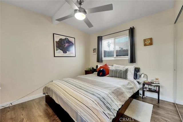 bedroom with lofted ceiling, hardwood / wood-style floors, ceiling fan, and a closet