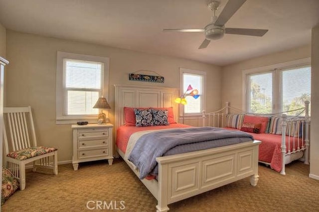 carpeted bedroom with ceiling fan and multiple windows