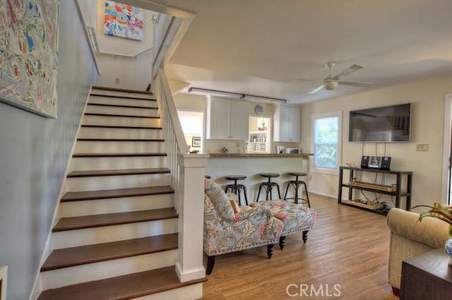 staircase featuring hardwood / wood-style floors and ceiling fan