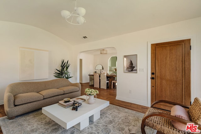 living room with brick ceiling, light hardwood / wood-style floors, vaulted ceiling, and a notable chandelier