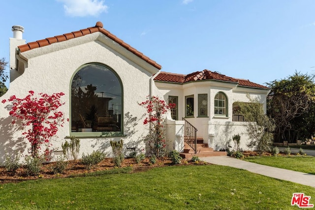 mediterranean / spanish-style home with a front yard