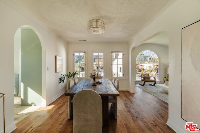 dining room featuring hardwood / wood-style flooring and a textured ceiling