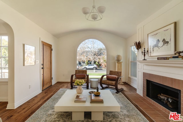 sitting room featuring vaulted ceiling, a brick fireplace, and dark hardwood / wood-style floors