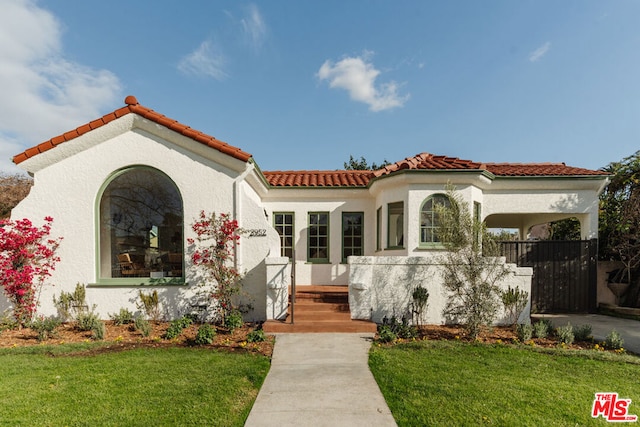 mediterranean / spanish home with a front yard