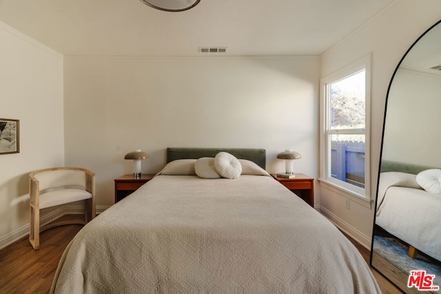 bedroom with hardwood / wood-style flooring and ornamental molding