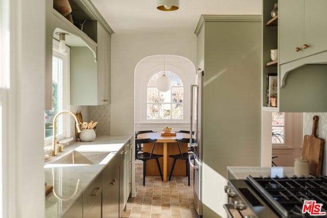 kitchen featuring tasteful backsplash, green cabinetry, and sink