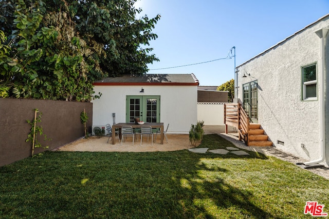 back of house with a patio, a lawn, and french doors