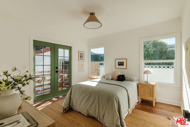 bedroom with french doors, multiple windows, and light hardwood / wood-style flooring