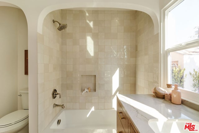 full bathroom featuring vanity, toilet, and tiled shower / bath