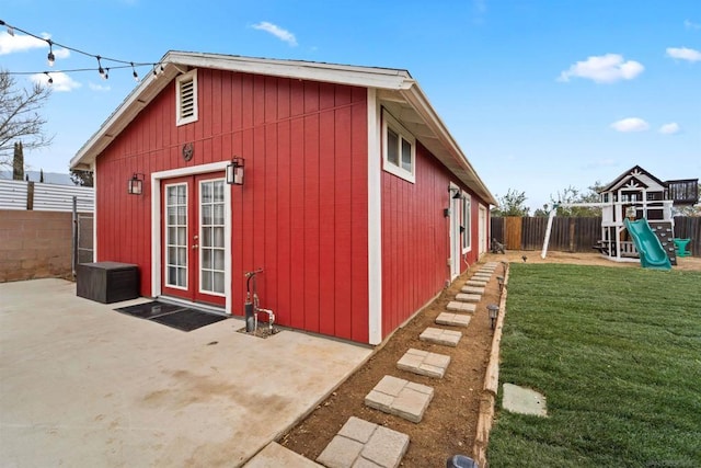 view of outbuilding with a playground and a lawn