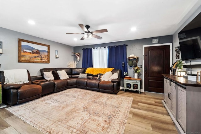 living room featuring ceiling fan and light wood-type flooring