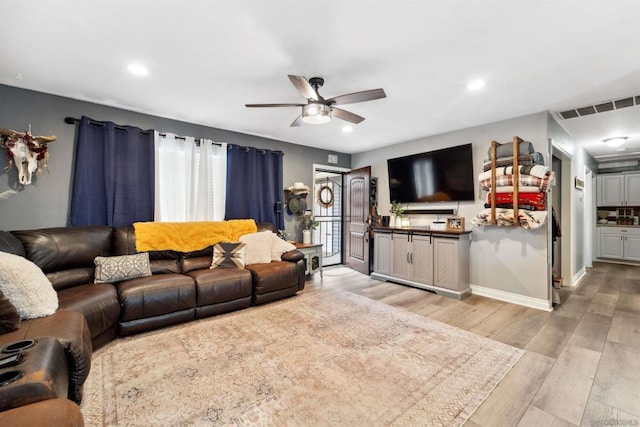 living room featuring ceiling fan and light wood-type flooring