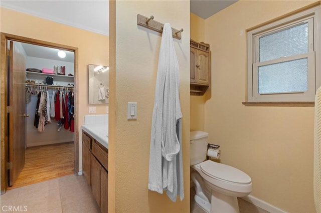 bathroom with vanity, ornamental molding, tile patterned floors, and toilet