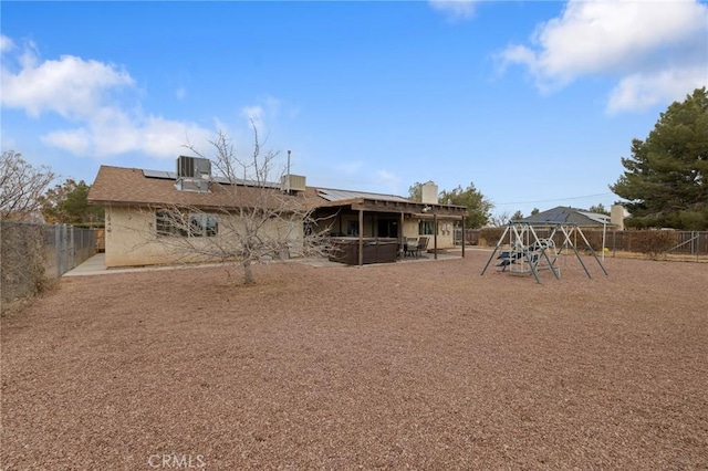 rear view of house with a patio, a playground, and central air condition unit