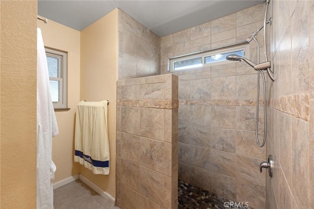 bathroom featuring a tile shower and a wealth of natural light