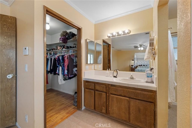 bathroom featuring crown molding, hardwood / wood-style floors, vanity, and ceiling fan