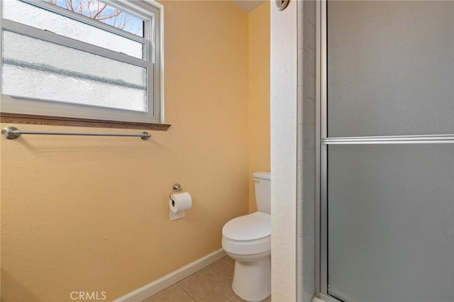 bathroom featuring walk in shower, tile patterned floors, and toilet