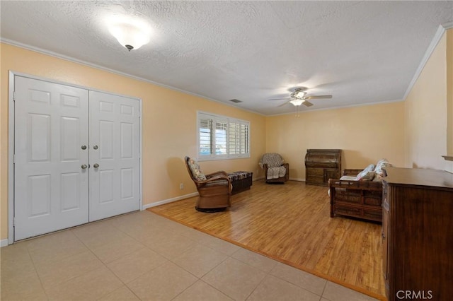 interior space featuring crown molding, ceiling fan, and a textured ceiling