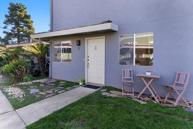 entrance to property featuring a lawn