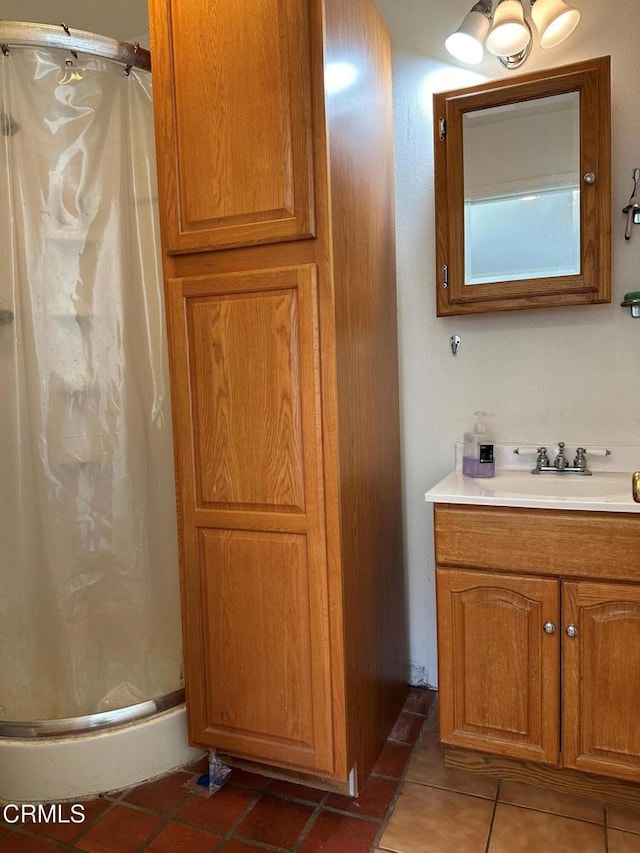 bathroom with vanity, tile patterned flooring, and a shower