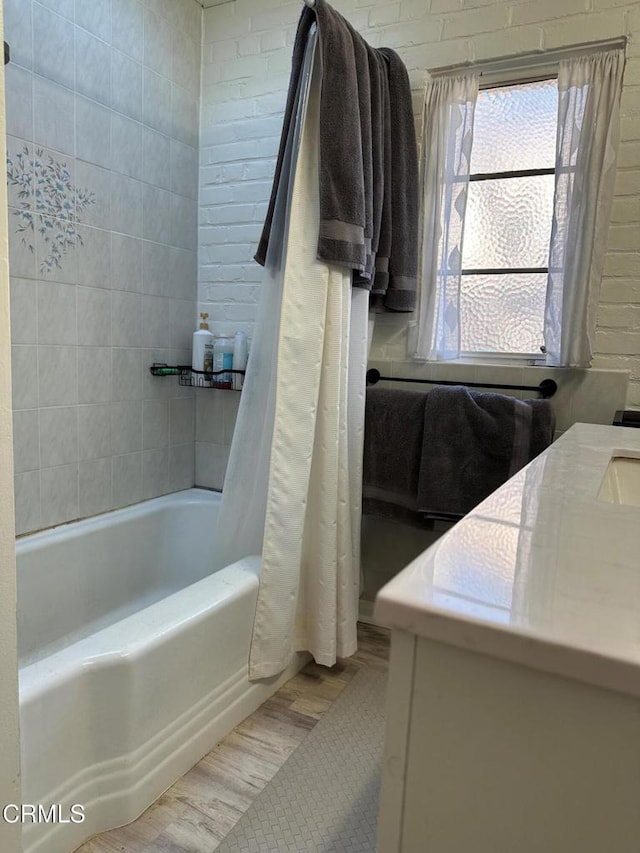 bathroom featuring wood-type flooring, shower / bathtub combination with curtain, and vanity