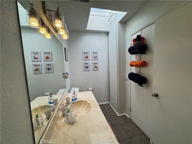 bathroom featuring vanity, a skylight, and tile patterned floors