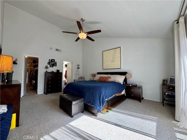 bedroom with high vaulted ceiling, a spacious closet, light colored carpet, and ceiling fan