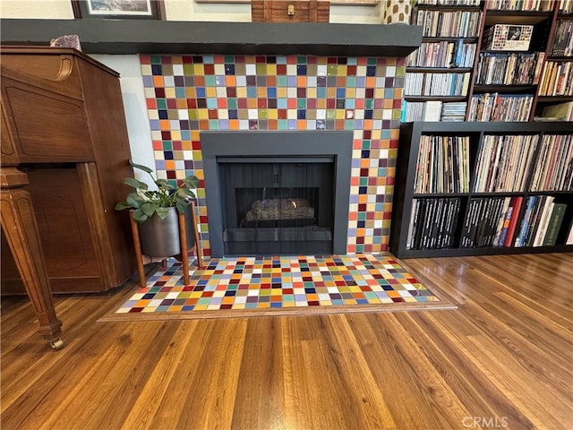 interior details with a tiled fireplace and hardwood / wood-style floors