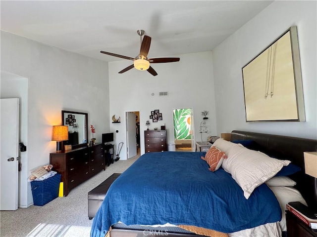 carpeted bedroom with high vaulted ceiling and ceiling fan