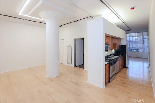 kitchen featuring stainless steel appliances, sink, and light hardwood / wood-style floors